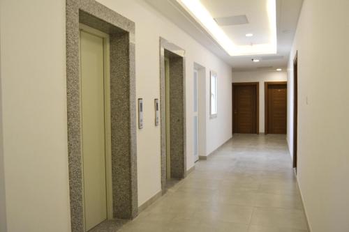 a corridor of an office building with white walls and tile floors at 151 in Kuwait