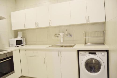 a kitchen with white cabinets and a washing machine at 151 in Kuwait