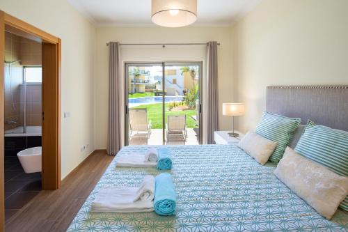 a bedroom with a large bed with towels on it at Marina Luxury Residence - Albufeira in Albufeira