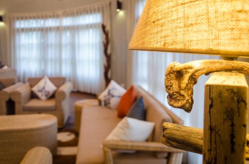 a living room with a lamp and a couch at Emburara Farm Lodge in Mbarara