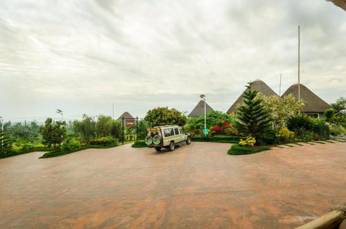 a white jeep parked in a parking lot at Emburara Farm Lodge in Mbarara