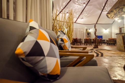a room with a couch with pillows on it at Emburara Farm Lodge in Mbarara