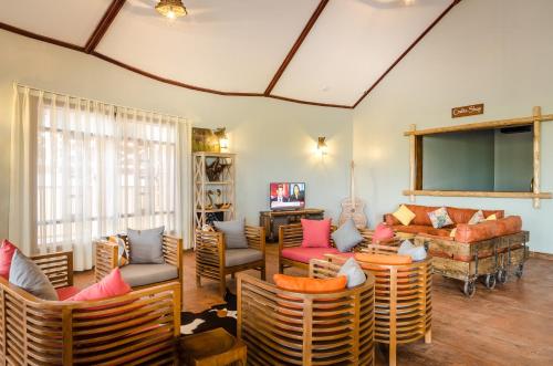 a living room with chairs and a couch at Emburara Farm Lodge in Mbarara