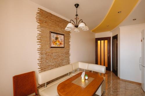 a living room with a table and a brick wall at СВІТЛО ЦІЛОДОБОВО Просторі апартаменти біля гідропарку Топільче in Ternopilʼ