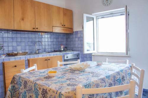 una cucina con tavolo e parete piastrellata blu di La Casa sul Mare a Ponza