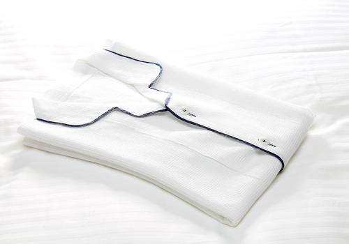 a white shirt with a blue collar on a bed at Daiwa Roynet Hotel Toyama-Ekimae in Toyama