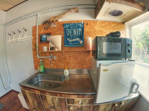 a kitchen with a sink and a refrigerator at 秘密基地 NO's ARROW ノーズアロー in Onna