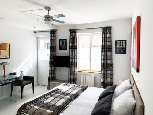 a bedroom with a bed and a desk and a window at Au Cœur des Remparts in Aigues-Mortes