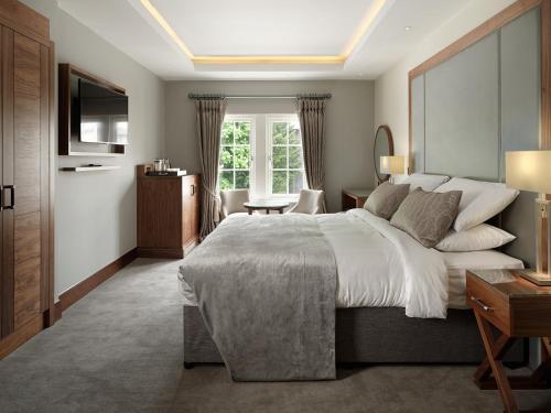 a bedroom with a large bed and a television at One Warwick Park Hotel in Royal Tunbridge Wells