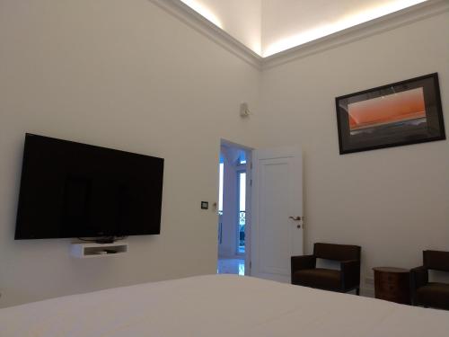a bedroom with a bed with a flat screen tv on the wall at Dear Garden in Donghe