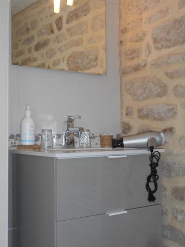 a white cabinet with a sink in a room at Espace Acu-Nature in Saint-Évarzec