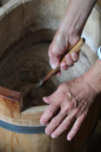 a person holding a knife in a wooden bowl at Jõeniidu Holiday House in Trolla