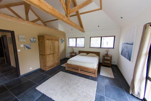 ein Schlafzimmer mit einem Bett in einem Zimmer mit Holzdecken in der Unterkunft VILLA KB'HOME in Le Touquet-Paris-Plage