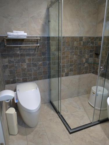 a bathroom with a toilet and a glass shower at Dear Garden in Donghe