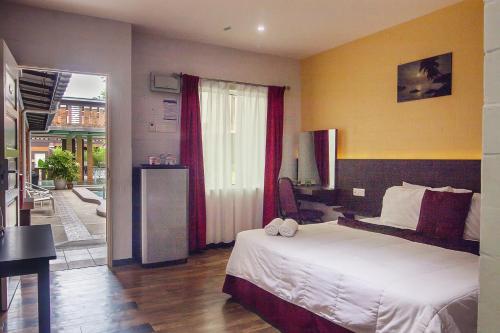 a hotel room with a bed and a balcony at Myvilla Langkawi Hotel in Pantai Cenang