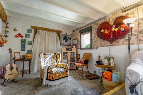 a room with a bed and a chair and a guitar at Refugio peregrinos Acacio & Orietta in Viloria de Rioja