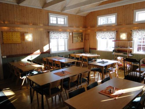 a dining room with tables and chairs and windows at Sunne Hembygdsgård B&B in Sunne