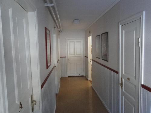 an empty hallway with white walls and white doors at Sunne Hembygdsgård B&B in Sunne