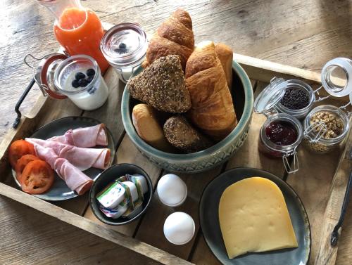un tavolo in legno con vassoio di pane e uova di Appartement OKP15 a Middelburg