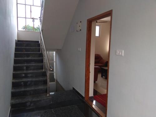 a stairway leading to a room with a window at Shree Mantra Residency and Homestay in Yercaud