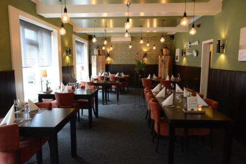 jadalnia ze stołami i krzesłami w restauracji w obiekcie Hotel De Beukelaer w mieście Roggel