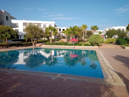 une piscine en face d'un bâtiment dans l'établissement Résidence Tafoult complexe Lunja village Agadir Imiouadar, à Agadir nʼ Aït Sa