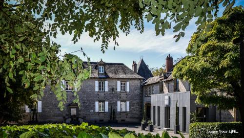 een oud kasteel met bomen ervoor bij Hôtel Château de Lacan in Brive-la-Gaillarde