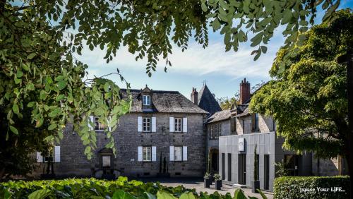 an old castle with trees in front of it at Hôtel Château de Lacan in Brive-la-Gaillarde