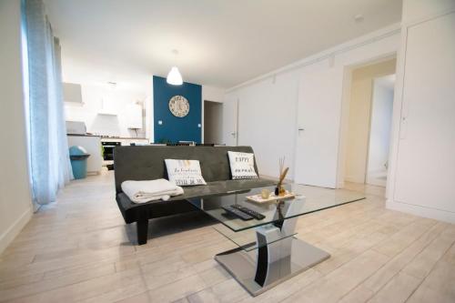 a living room with a couch and a glass table at Appartement hypercentre Tarbes in Tarbes