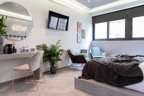 a bedroom with a bed and chairs and a mirror at 14 Reasons Why Hotel Athens in Athens