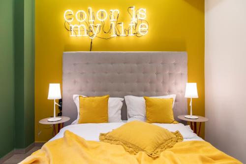 a bedroom with a large bed with yellow pillows at 14 Reasons Why Hotel Athens in Athens