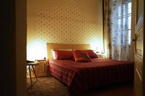 a bedroom with a bed with red sheets and a window at 0.3 Stanze in Trieste