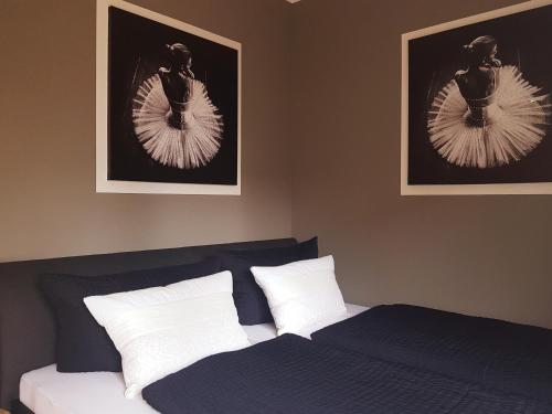 - une chambre avec un lit et deux photos sur le mur dans l'établissement Ferienwohnung Lilly, à Karlshagen