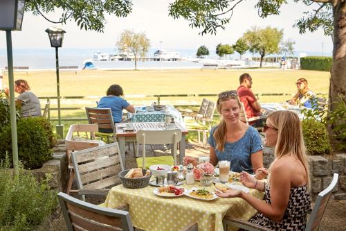 two women sitting at a table eating food at a restaurant at Seewirt & Haus Attila in Podersdorf am See