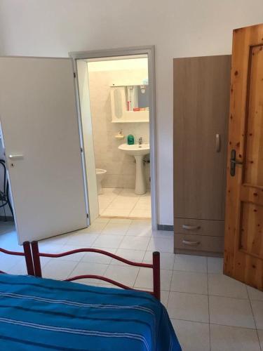 a room with a bed and a bathroom with a sink at Villa Brigida in Manduria