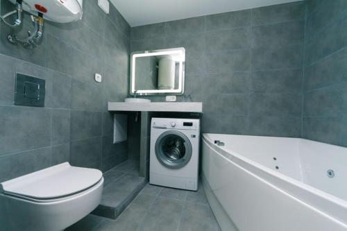 een badkamer met een wasmachine en een bad bij Hotrent Bessarabka Arena in Kiev