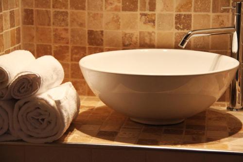 a bathroom with a bowl sink and a pile of towels at La casa di Chiara in Diano dʼAlba