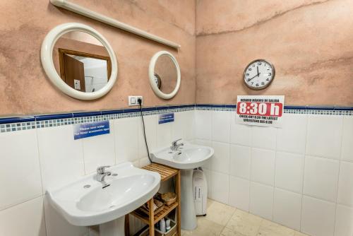 uma casa de banho com 2 lavatórios e um espelho em Refugio peregrinos Acacio & Orietta em Viloria de Rioja