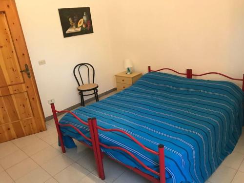a bedroom with a bed with a blue blanket on it at Villa Brigida in Manduria