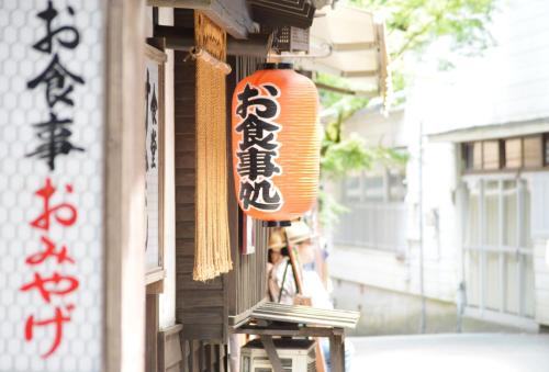 a sign on the side of a building with writing on it at Kurokawa Onsen Oku no Yu in Minamioguni