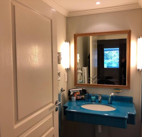 a bathroom with a blue sink and a mirror at SWING RESIDENCE GOLF LA BAULE in Saint-André-des-Eaux