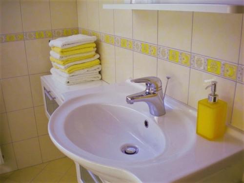 ein weißes Waschbecken im Bad mit Handtüchern in der Unterkunft APARTMA PR TAVČARJU in Zgornje Gorje
