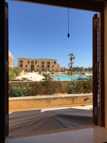an open door with a view of a pool at Fort Chambray in Għajnsielem
