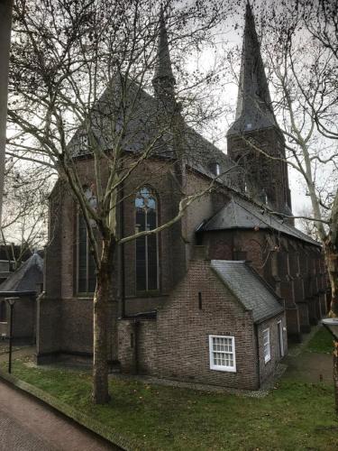 a large brick church with a tree in front of it at Bed & Breakfast Huis Sevenaer in Zevenaar