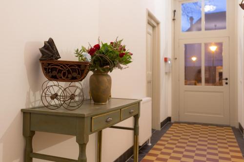 a vase on a table with a basket on it at Bed & Breakfast Huis Sevenaer in Zevenaar
