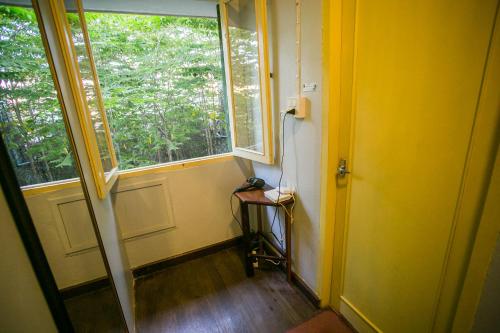 a yellow room with a door and a window at Barn1920s Hostel in Vientiane