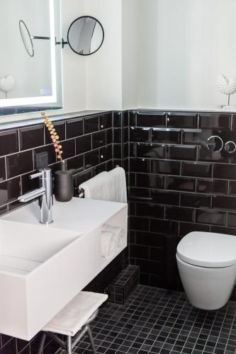 a bathroom with a white sink and a toilet at Boutique Hotel K7 in Bad Nauheim