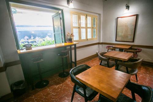 a restaurant with two tables and chairs and a window at Barn1920s Hostel in Vientiane