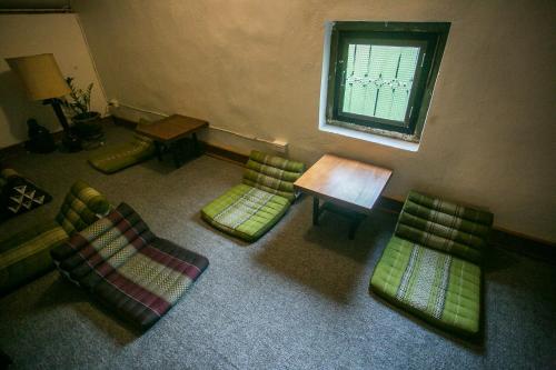 a room with chairs and a table and a window at Barn1920s Hostel in Vientiane