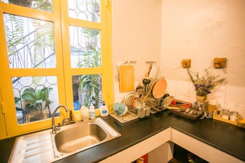 a kitchen counter with a sink and a window at Barn1920s Hostel in Vientiane